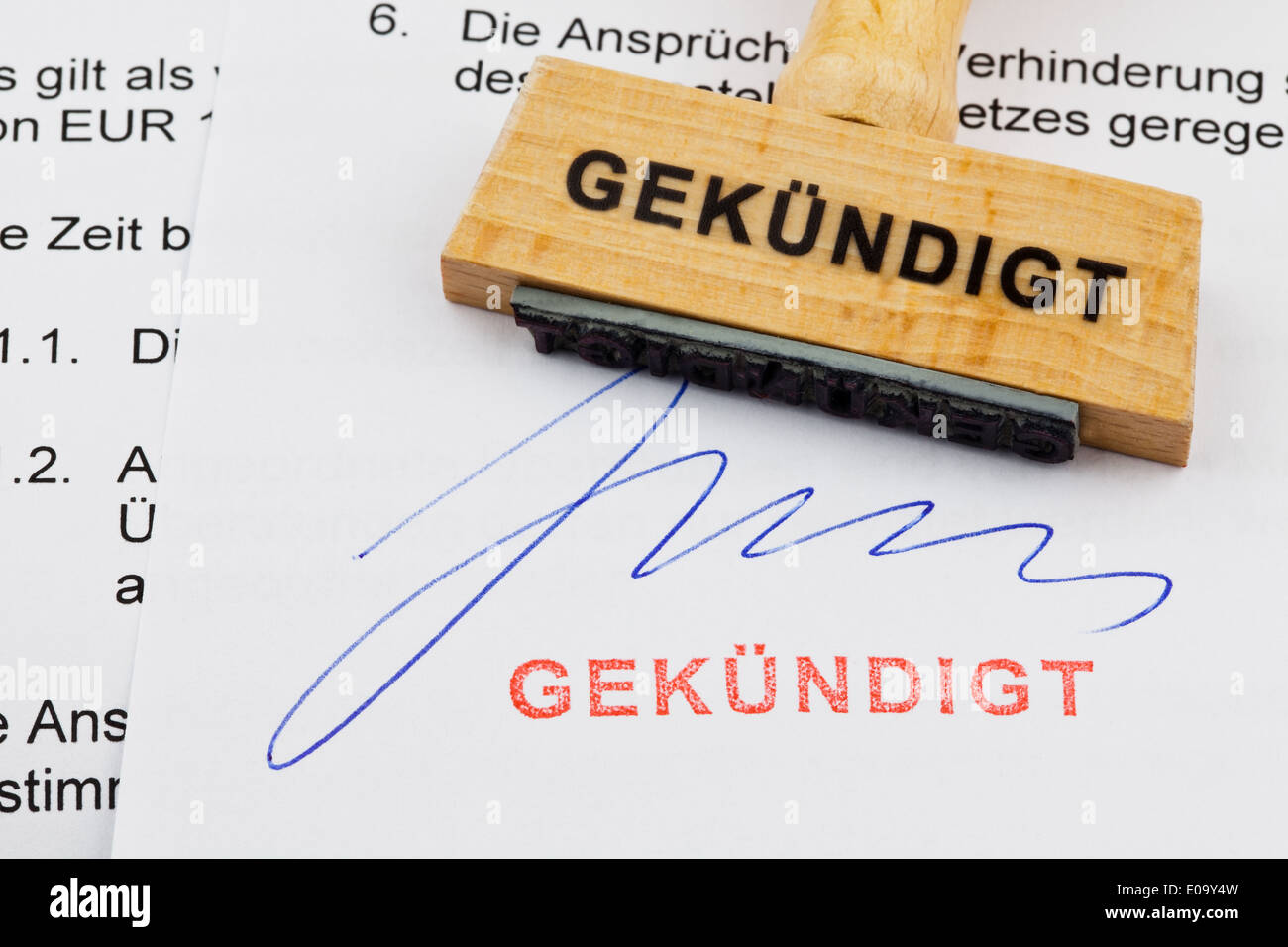 A stamp of wood lies on a document. German label: discontinued, Ein Stempel aus Holz liegt auf einem Dokument. Deutsche Aufschri Stock Photo