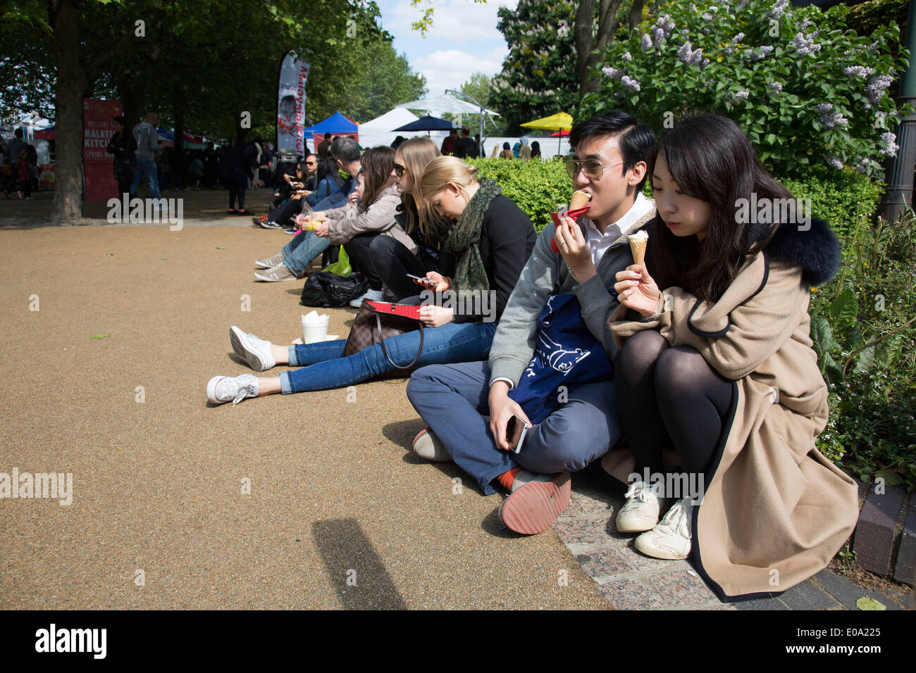 Friends eating ice cream during a food festival on the Southbank. South Bank is a significant arts and entertainment district, it's riverside walkway busy with visitors and tourists. London, UK. Stock Photo