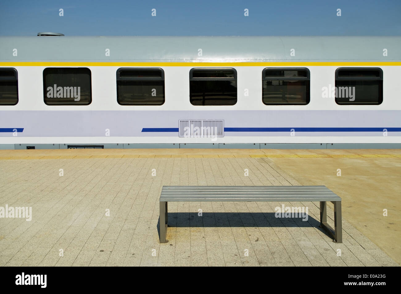 A railway passenger car and a bench on the platform Stock Photo