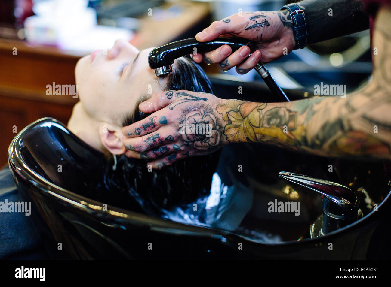 Close up of barber washing young mans hair Stock Photo