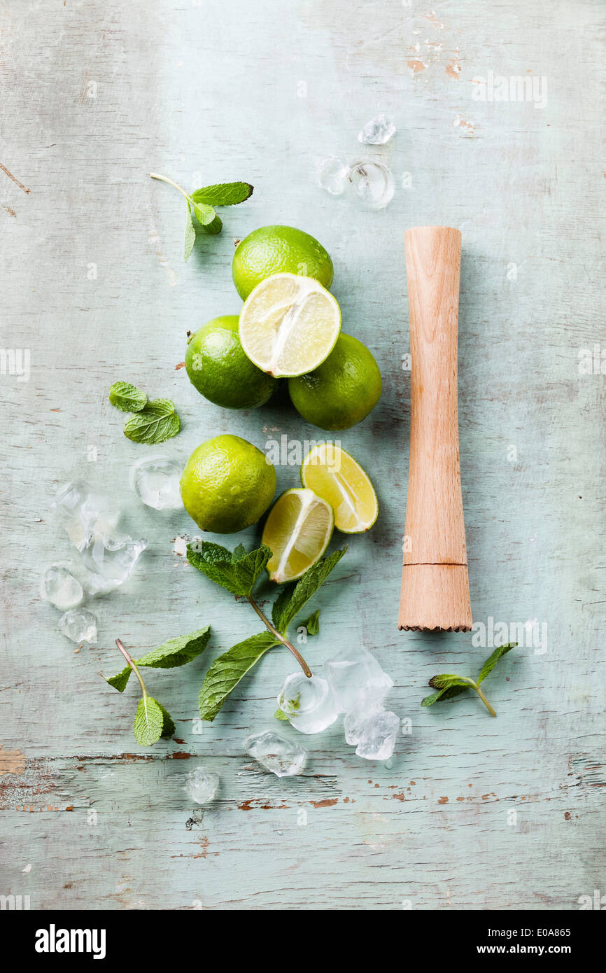 Ingredients for making mojitos Ice cubes, mint leaves and lime on blue background Stock Photo