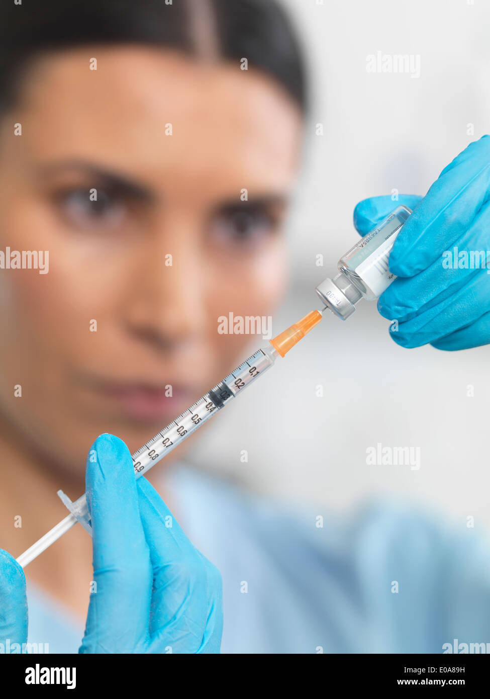 Nurse preparing a syringe for an injection Stock Photo