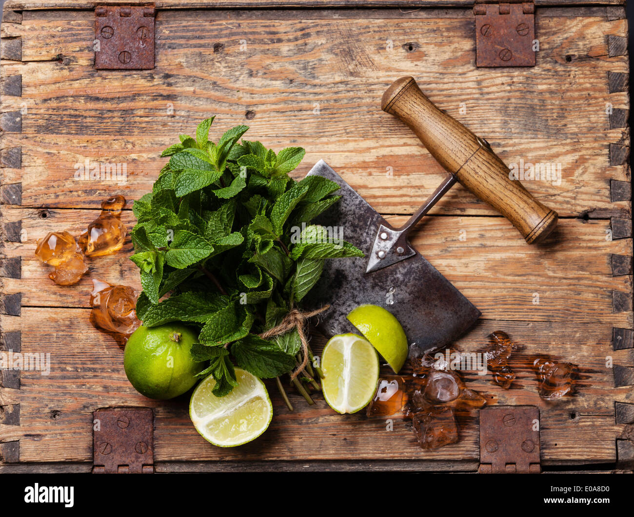 Ingredients for making mojitos Ice cubes, mint leaves and lime on wooden background Stock Photo