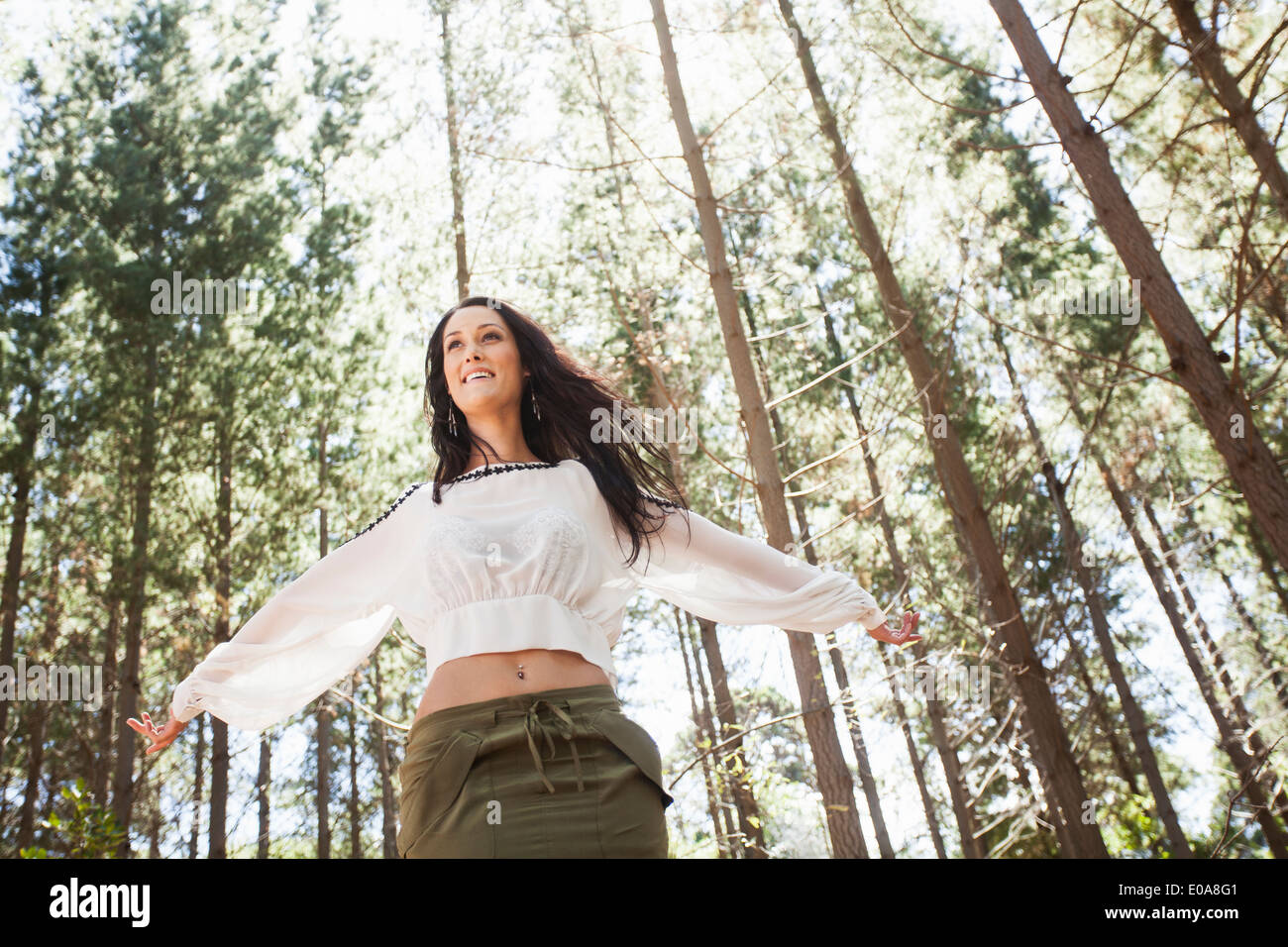 Young woman in forest, arms outstretched Stock Photo