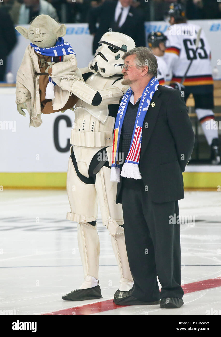 Nuremberg, Germany. 06th May, 2014. A man in a Star Wars Stormtrooper costume who holds up a Yoda Star Wars puppet and the inventor of the Yoda figure Nick Malesy stand on the ice prior to the ice hockey friendly match Germany vs USA in Nuremberg, Germany, 06 May 2014. Photo: DANIEL KARMANN/dpa/Alamy Live News Stock Photo