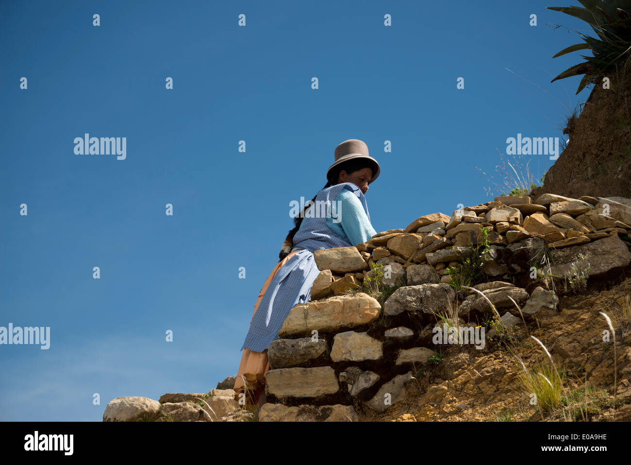 Bolivian woman at an Inca ruin on the Isla del Sol, Lake Titicaca, Bolivia. Stock Photo