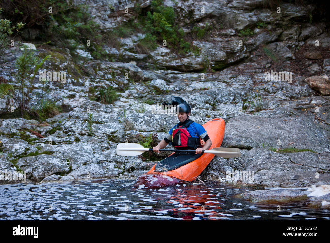 Mid adult man moving kayak from waters edge into river Stock Photo Alamy