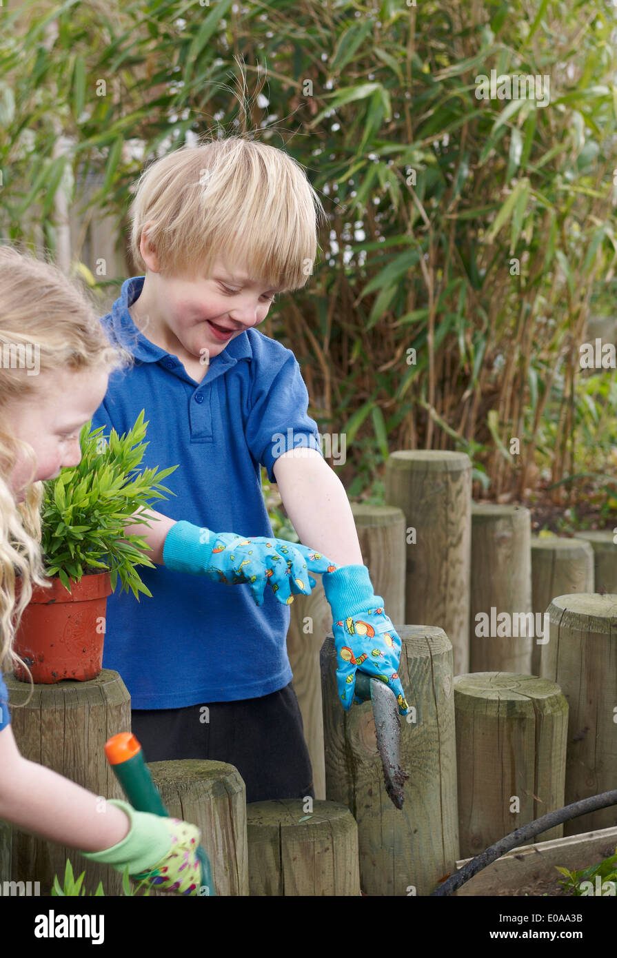 School boy and girl planting in garden Stock Photo - Alamy