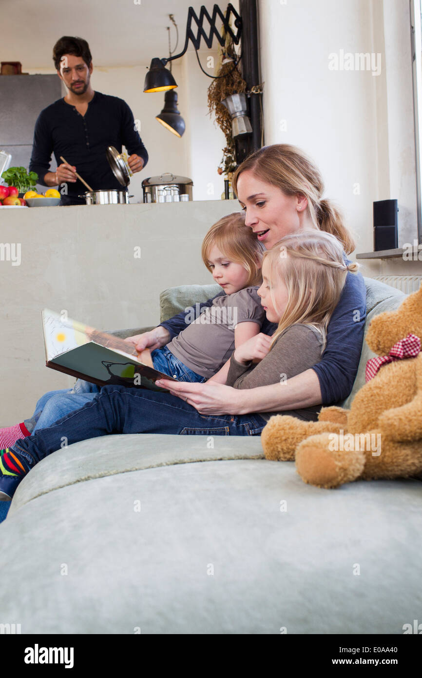 Mother and two daughters reading storybook Stock Photo