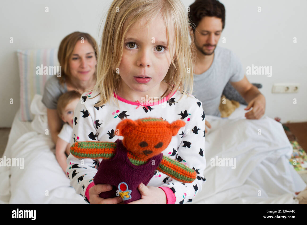 Portrait of sullen young girl on her parents bed Stock Photo