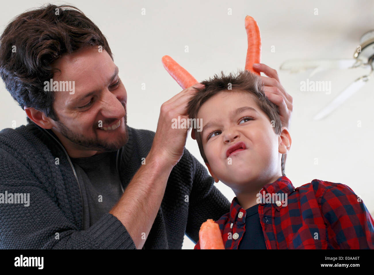 Father and son with carrot horns Stock Photo