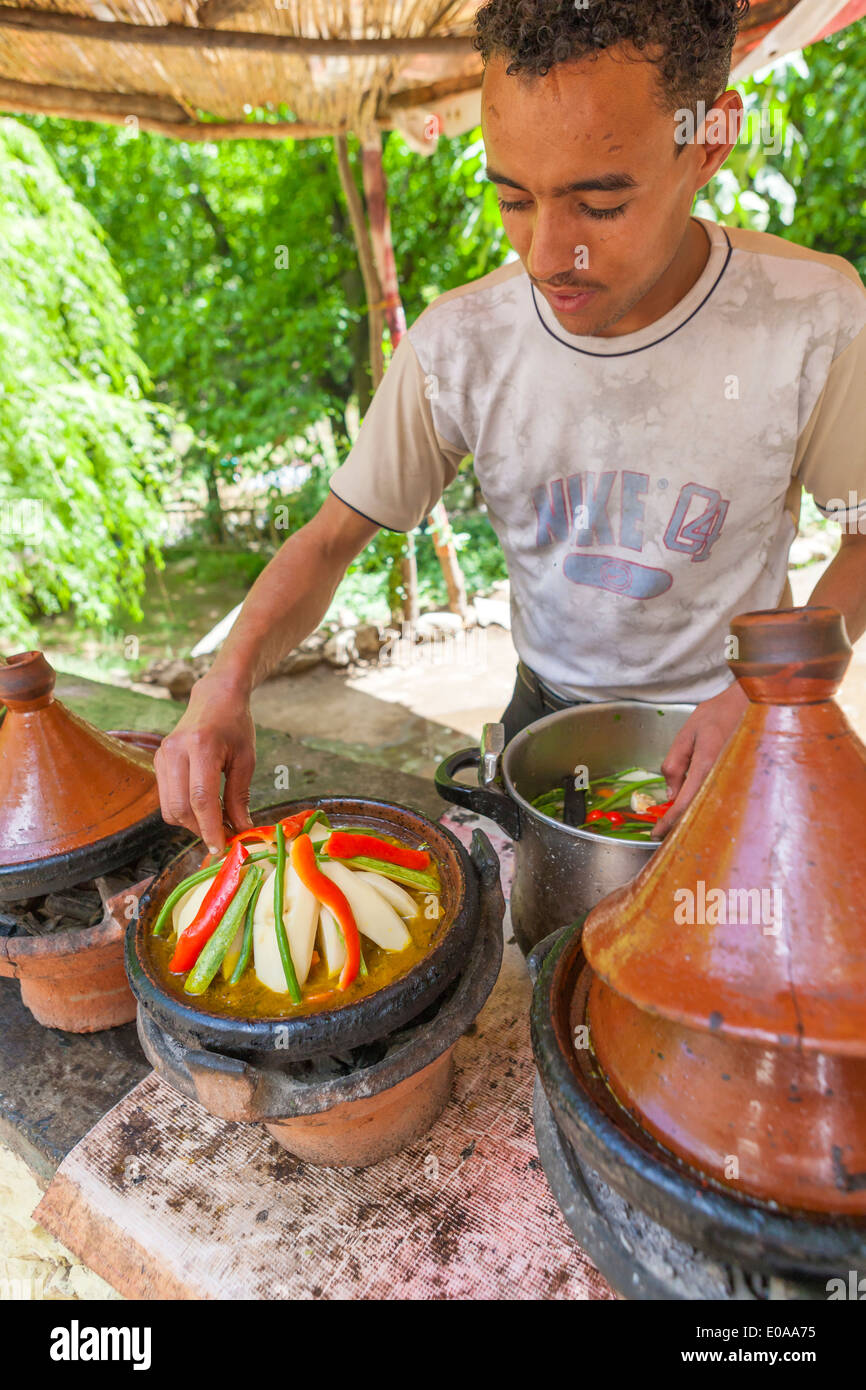 Man preparing tajine Moroccan speciality, in a typical pot, Ourika Valley, Morocco. Stock Photo