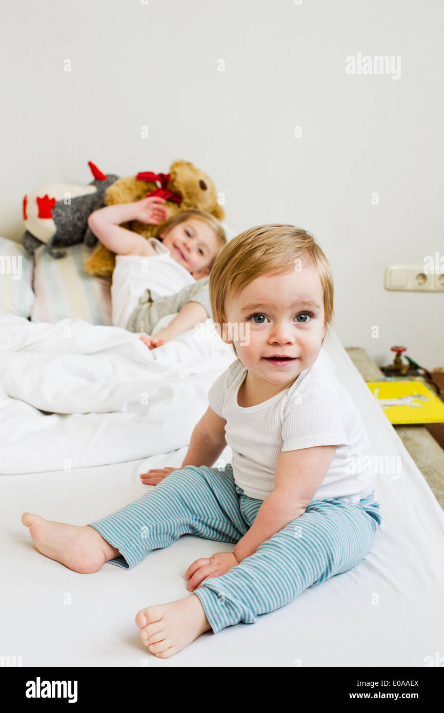 Portrait of baby girl on bed with her sister Stock Photo