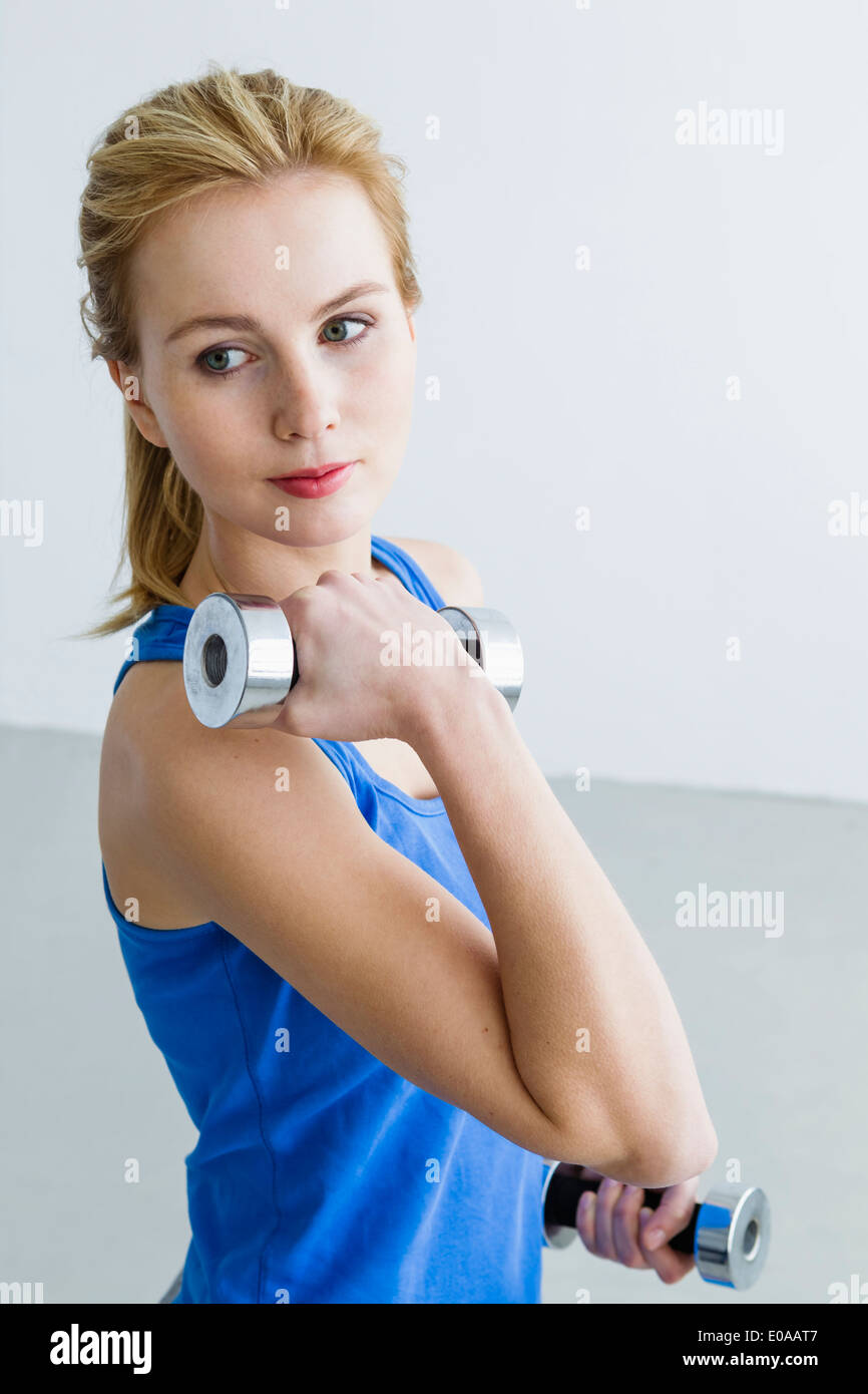 Young woman lifting weights Stock Photo