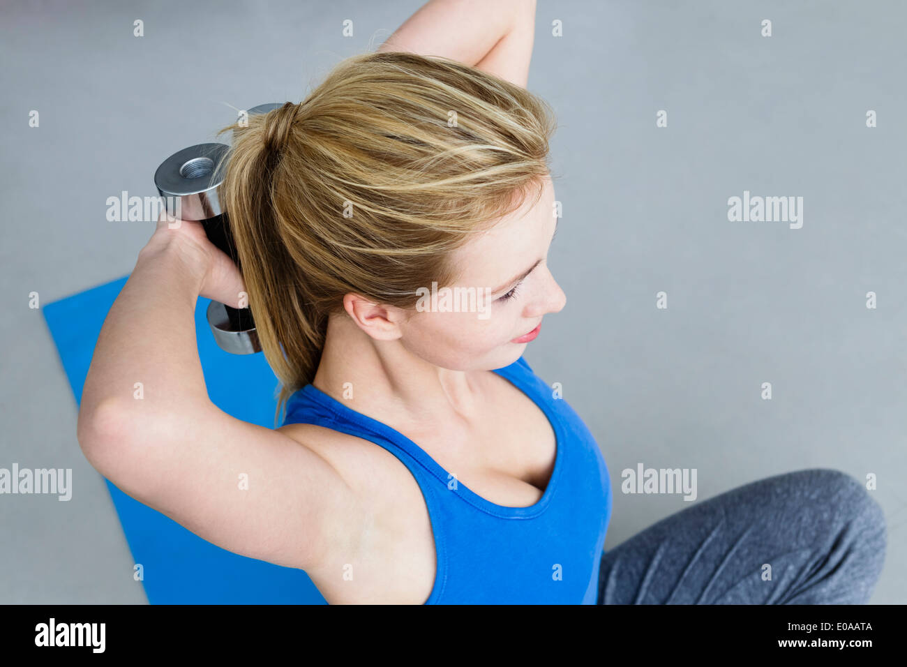 Young woman lifting weights Stock Photo