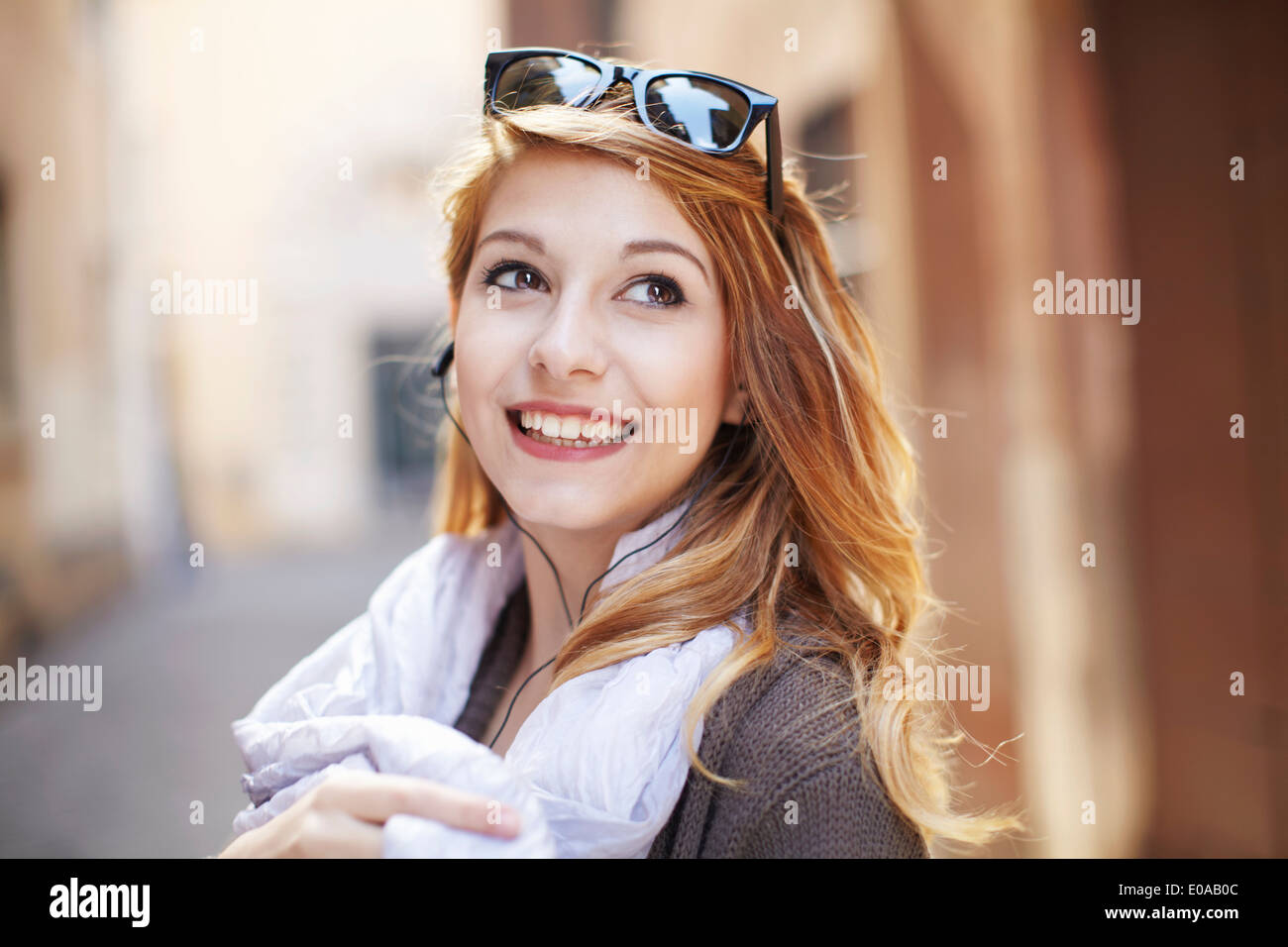 Sophisticated young woman looking back on street Stock Photo