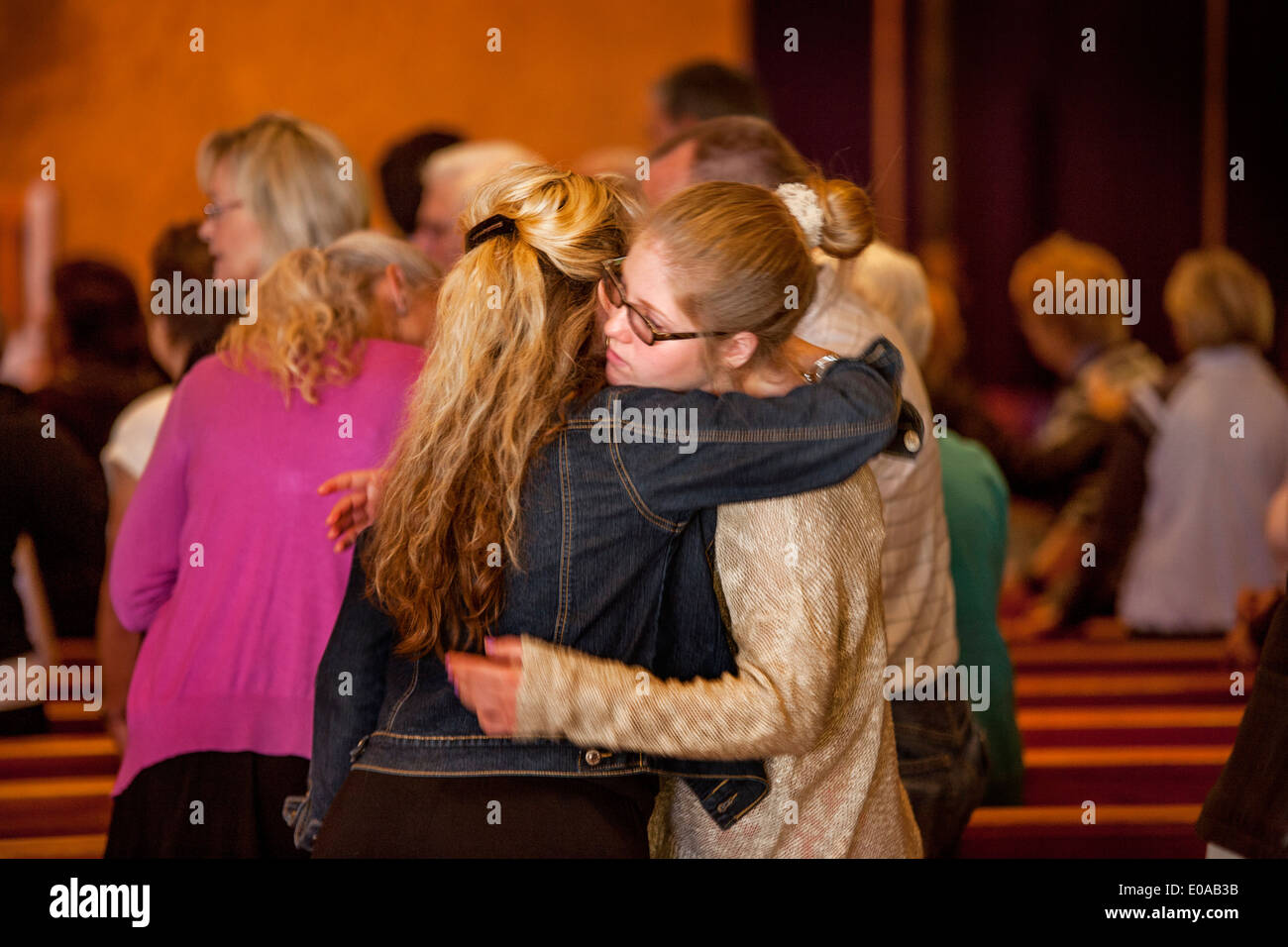 A mother and her teenage daughter hug at the conclusion of mass at a Laguna Niguel, CA, Catholic church. Stock Photo