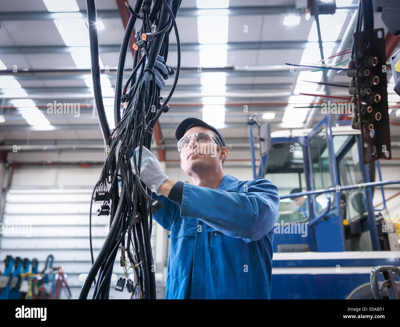 Engineer installing new electrics in truck repair factory Stock Photo