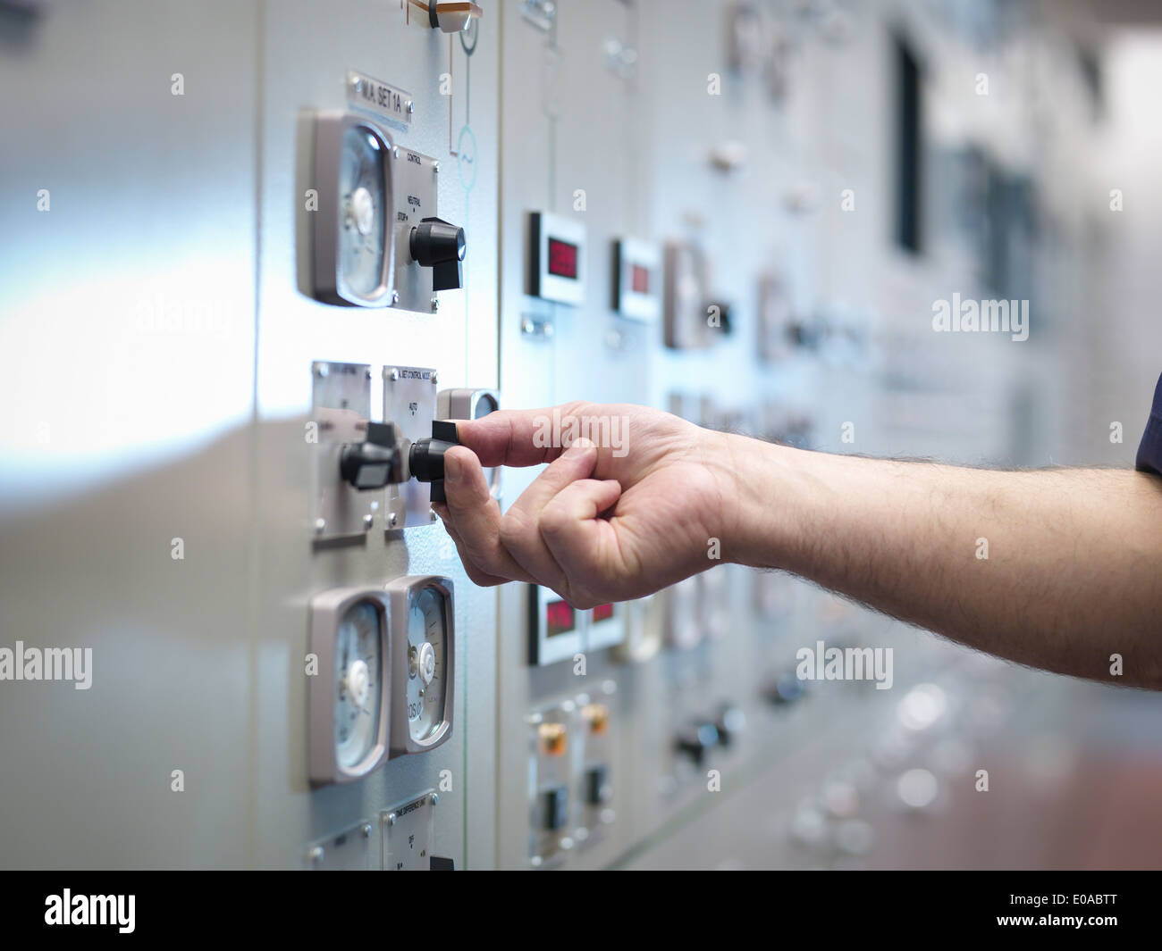 Close up of hand adjusting control in nuclear power station control room simulator Stock Photo