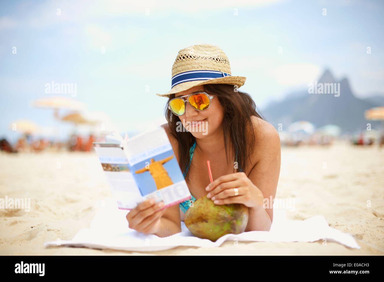 Mature woman reading tourist guide, Ipanema beach, Rio De Janeiro, Brazil Stock Photo