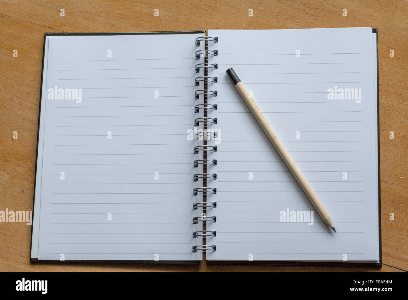 Open notebook on desk with a pencil Stock Photo
