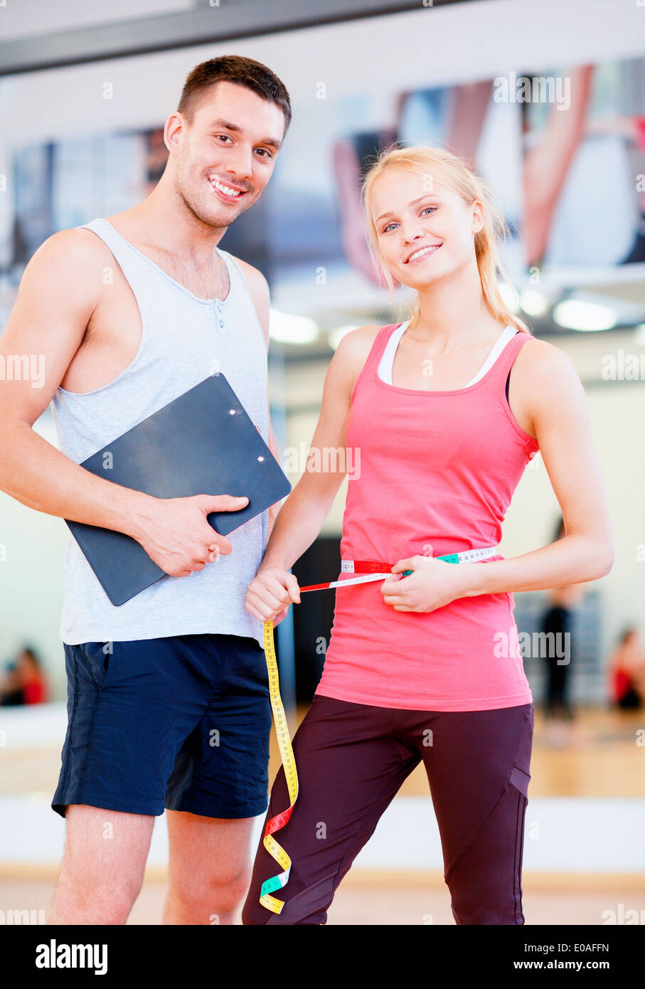 two smiling people with clipboard and measure tape Stock Photo