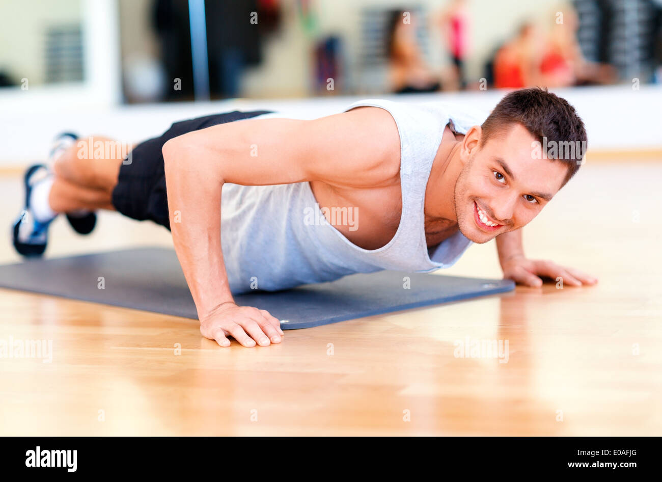 smiling man doing push-ups in the gym Stock Photo