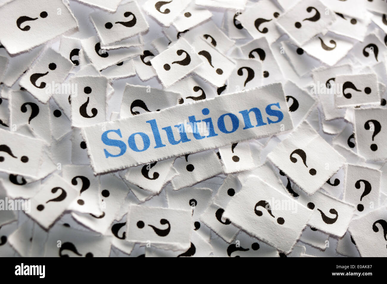 solutions on question marks on white papers -hard light Stock Photo - Alamy