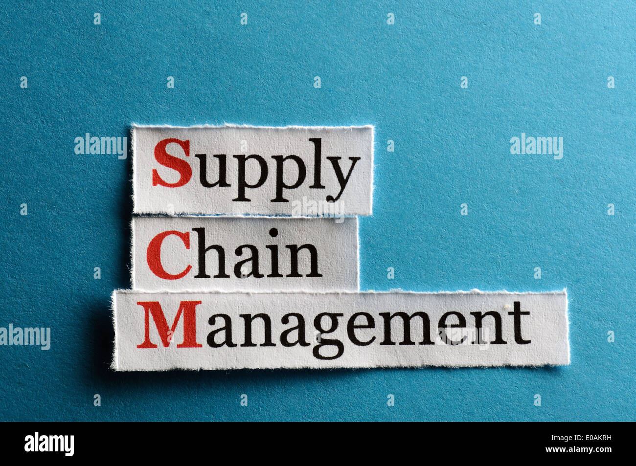 SCM Supply Chain Management acronym on blue paper Stock Photo
