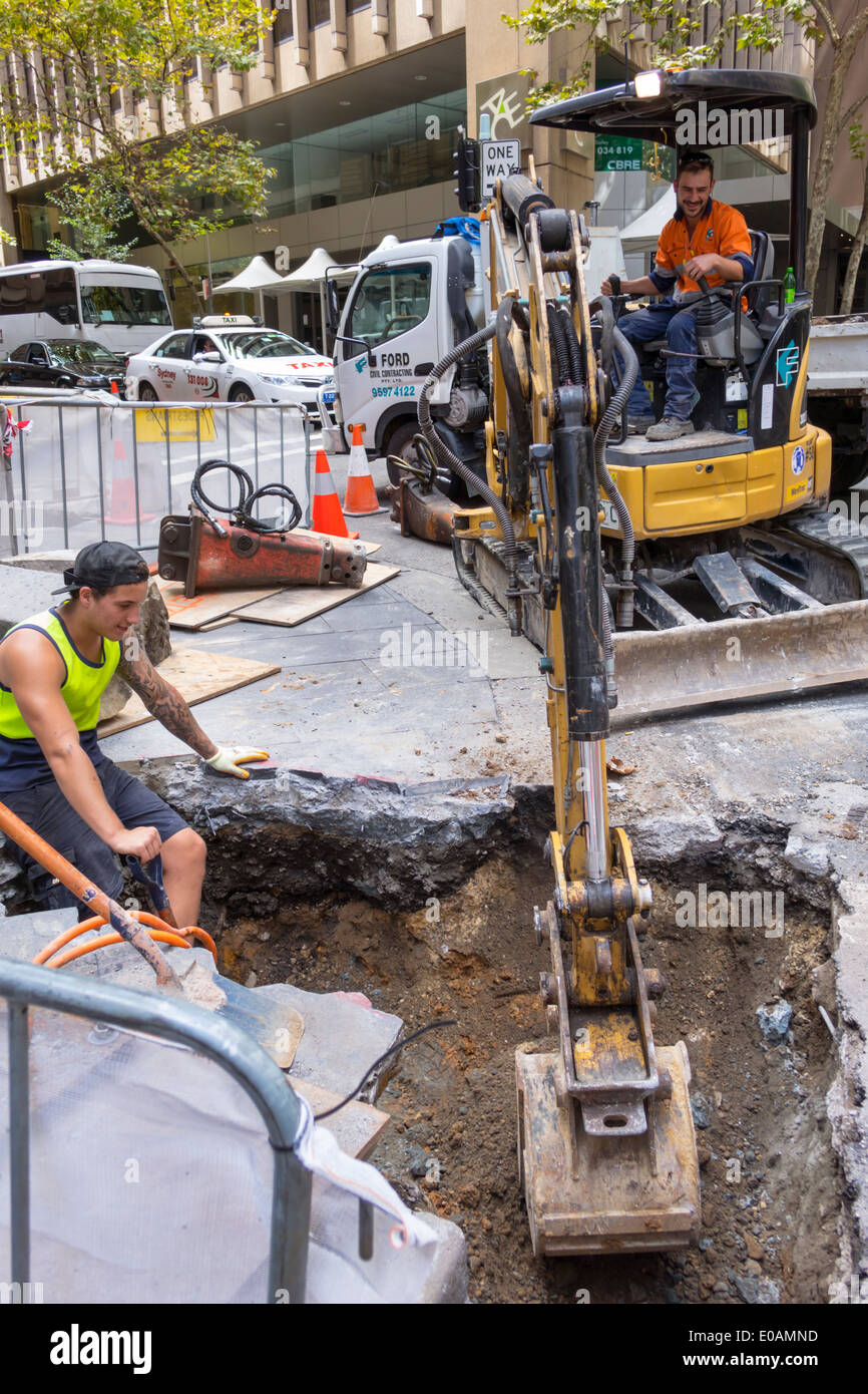 Sydney Australia,repair,maintenance,road,sidewalk,excavator,man men male,operator,worker,AU140309003 Stock Photo