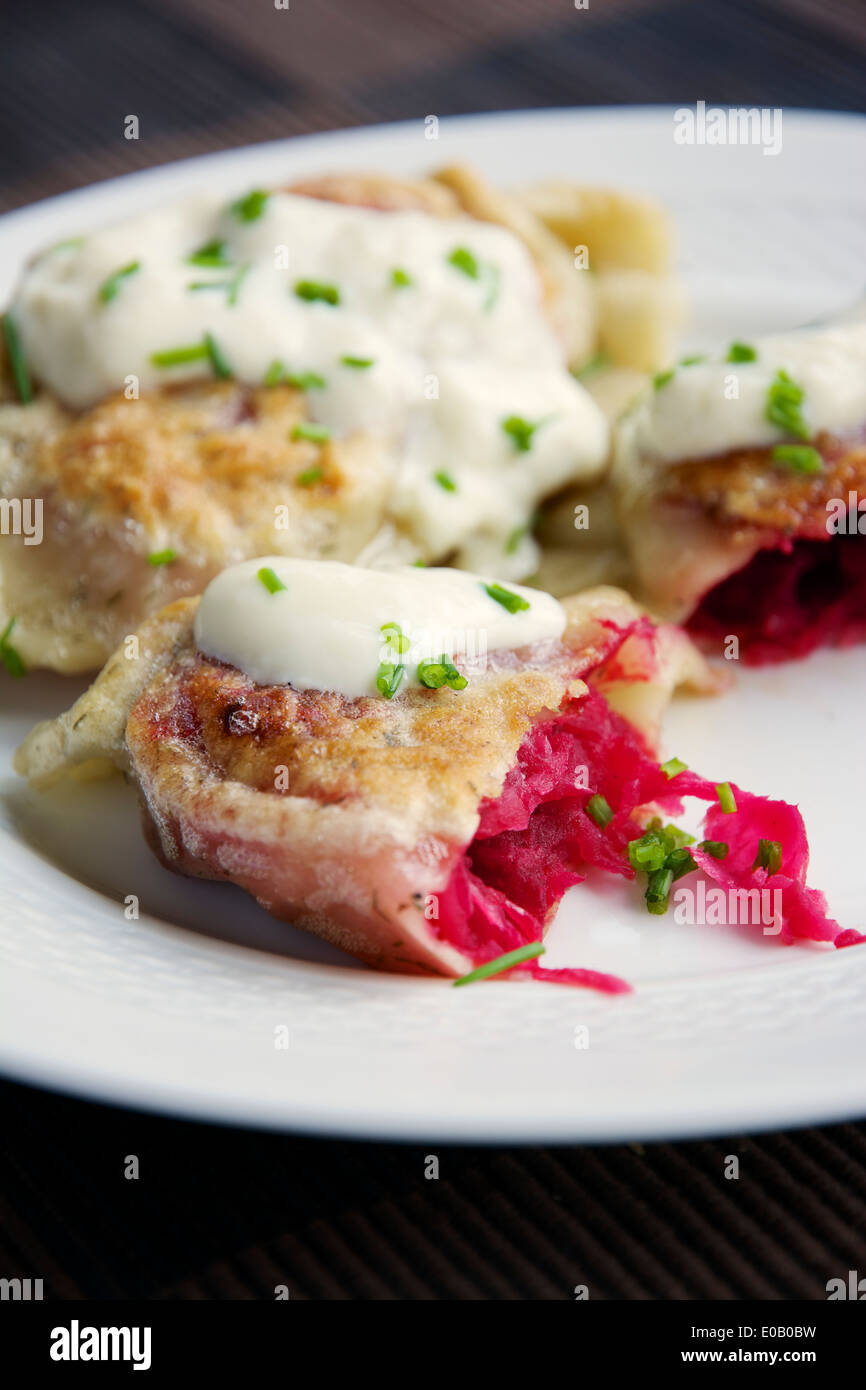 Fried herbed pierogi with a beet, sauerkraut and potato filling, served