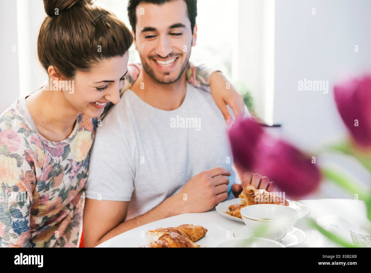 Laughing young couple at breakfast table Stock Photo