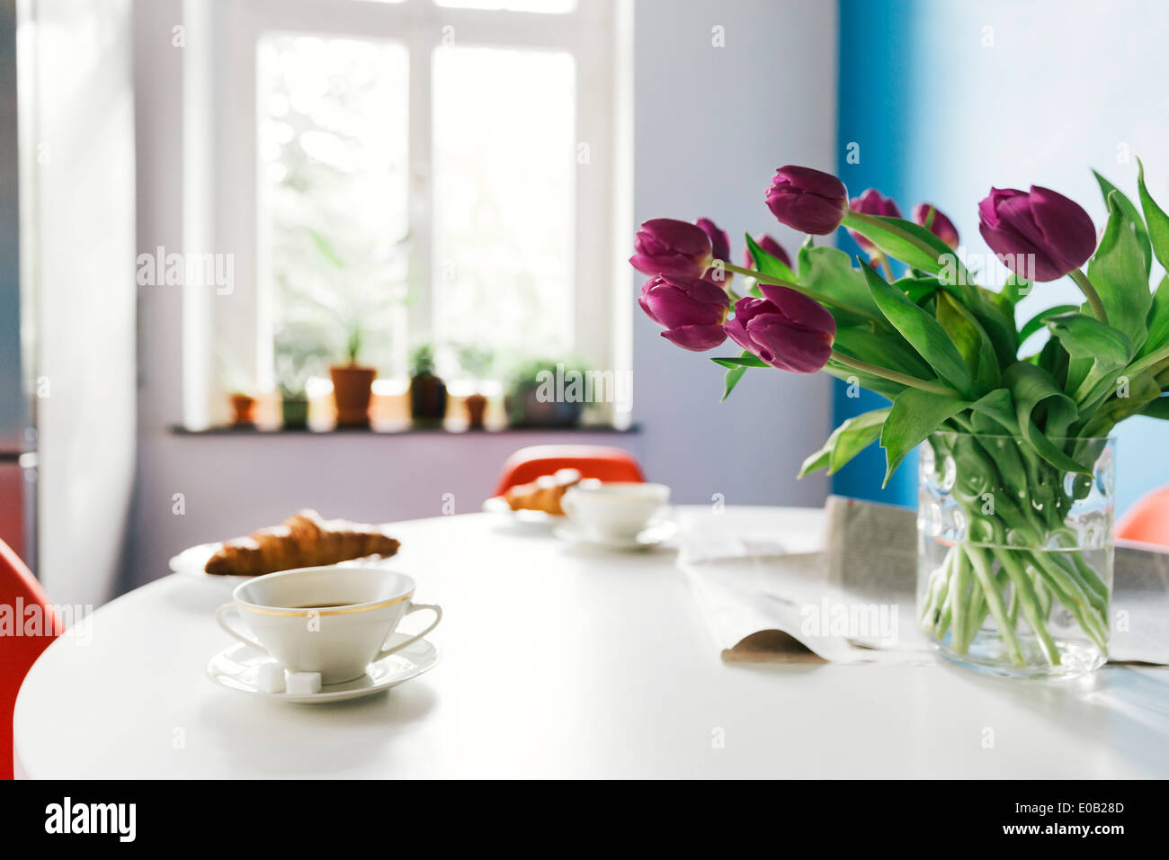 Breakfast table with tulips, croissants and cups of coffee Stock Photo