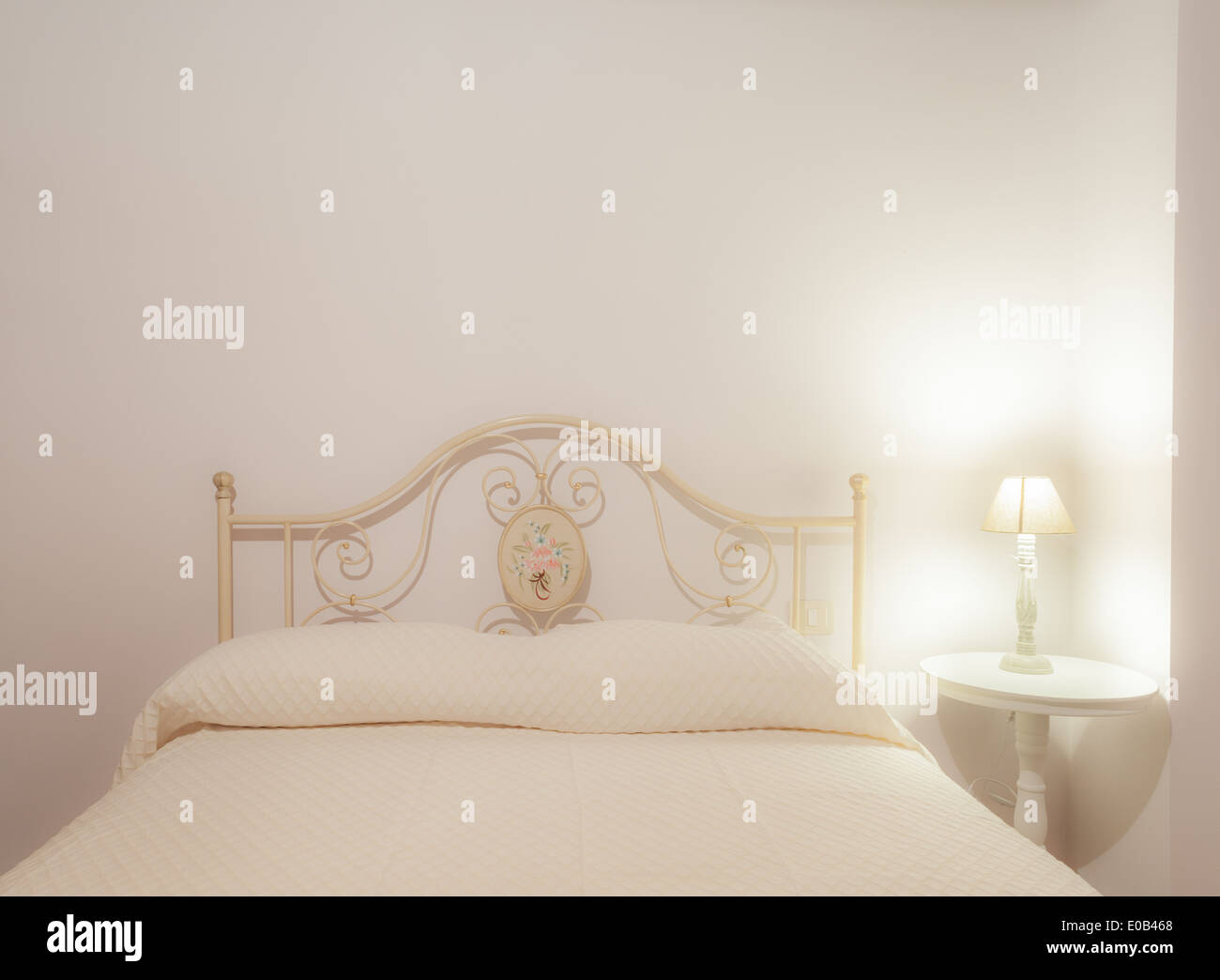 a luxurious bedroom with a lamp over a bed side table Stock Photo