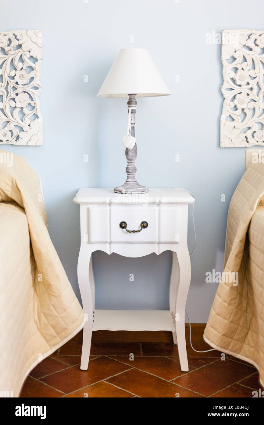 a luxurious bedroom with a lamp over a bed side table Stock Photo
