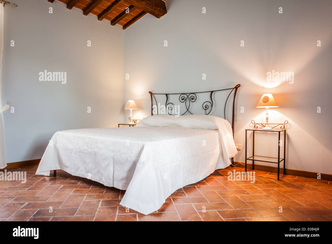 a luxurious bedroom with a lamp over a bed side table Stock Photo