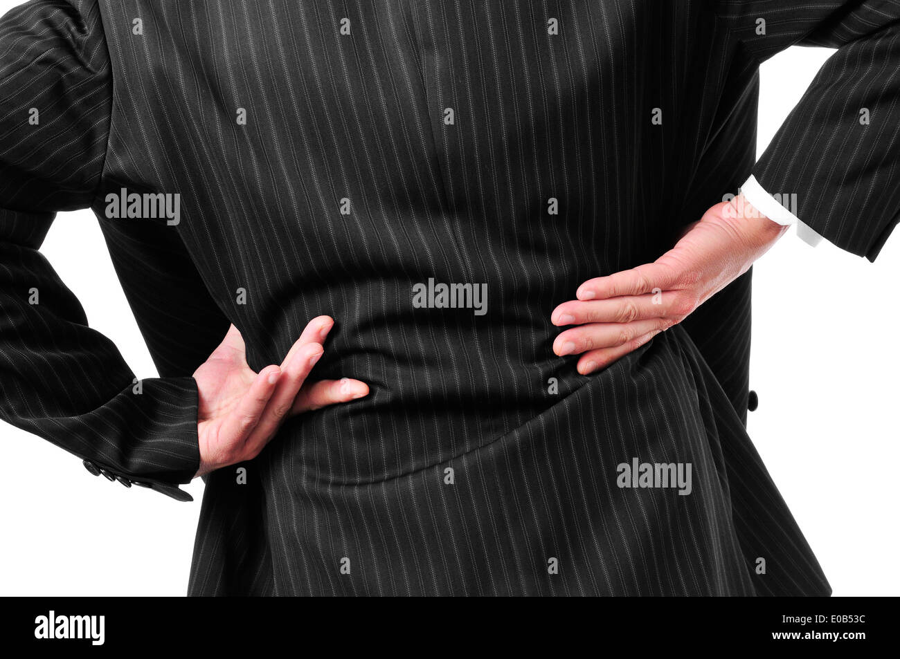 man wearing a suit with his hands in his low back because of his low back pain Stock Photo