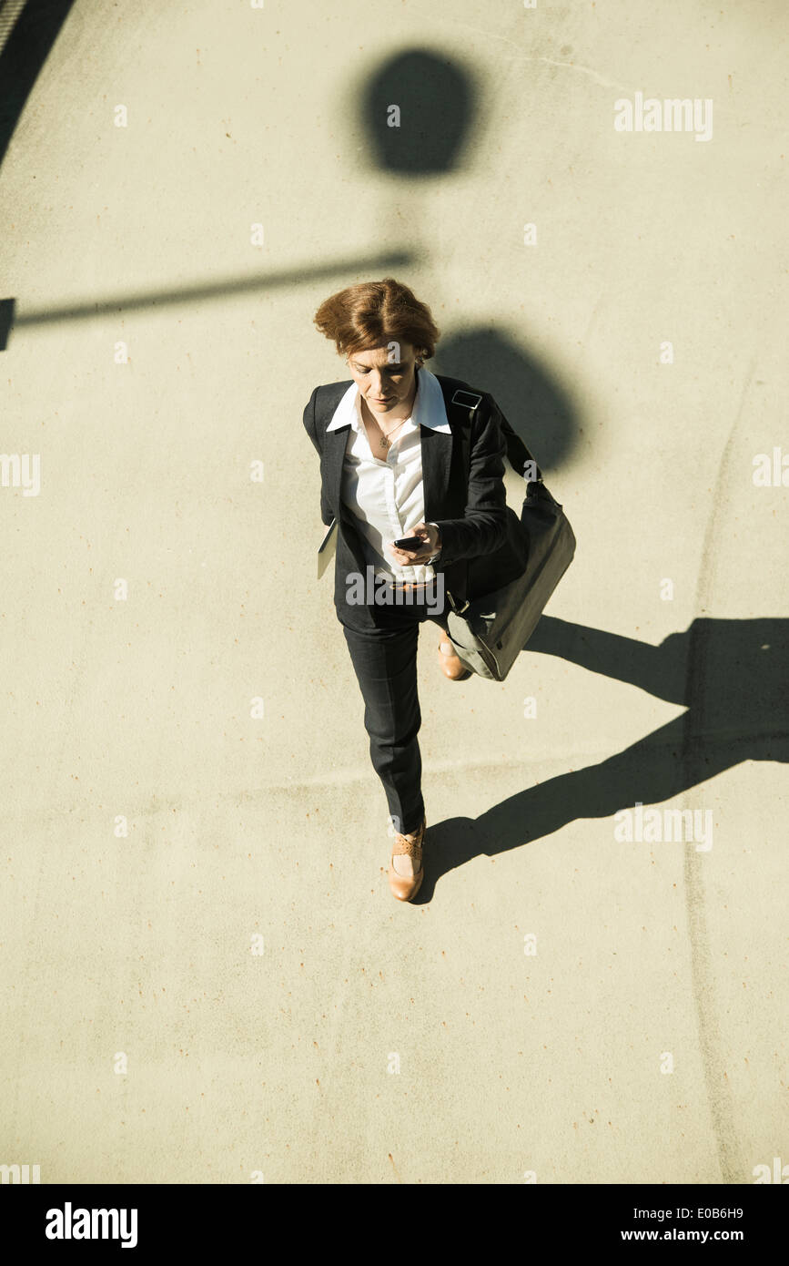 Business woman hurrying on parking level, elevated view Stock Photo