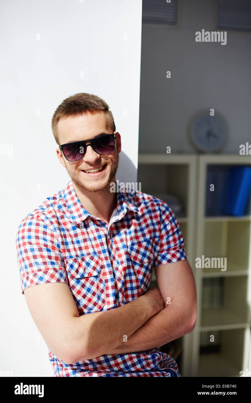 Young guy in sunglasses smiling and looking at camera Stock Photo