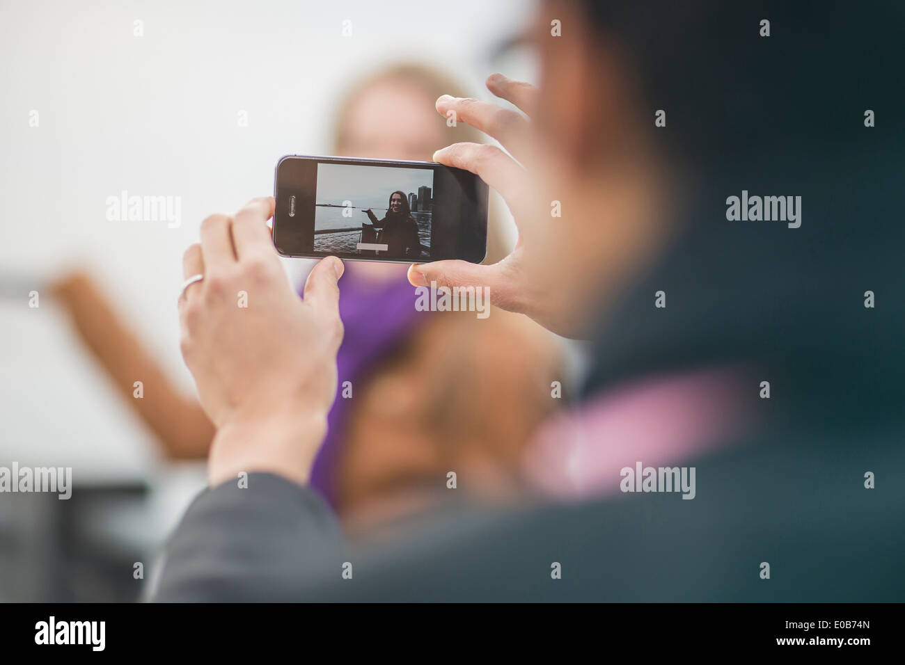 Close up of young man photographing girlfriend on camera phone Stock Photo
