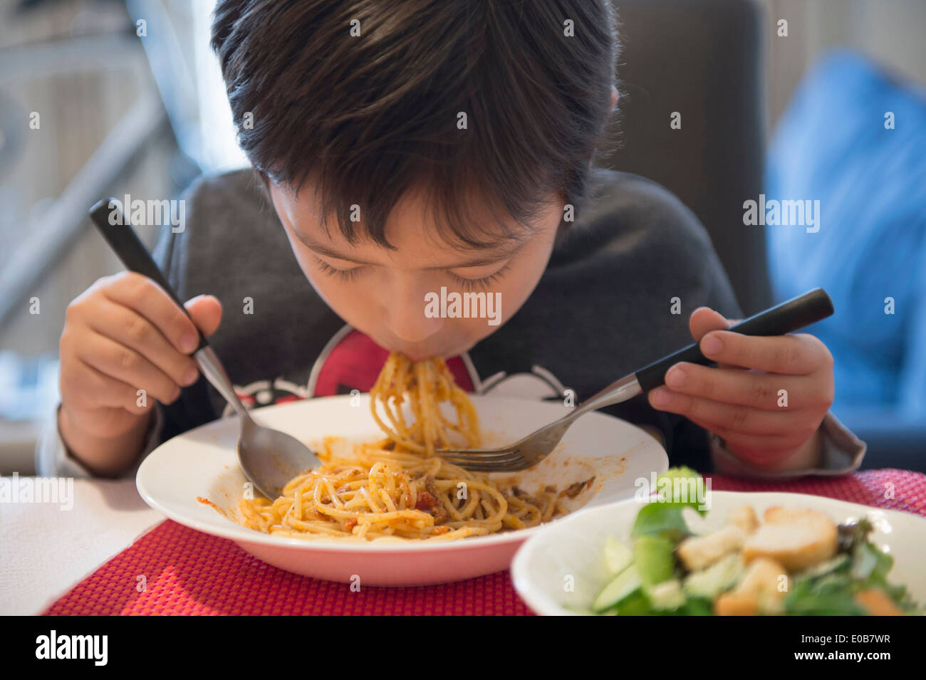 Boy eating spaghetti Stock Photo