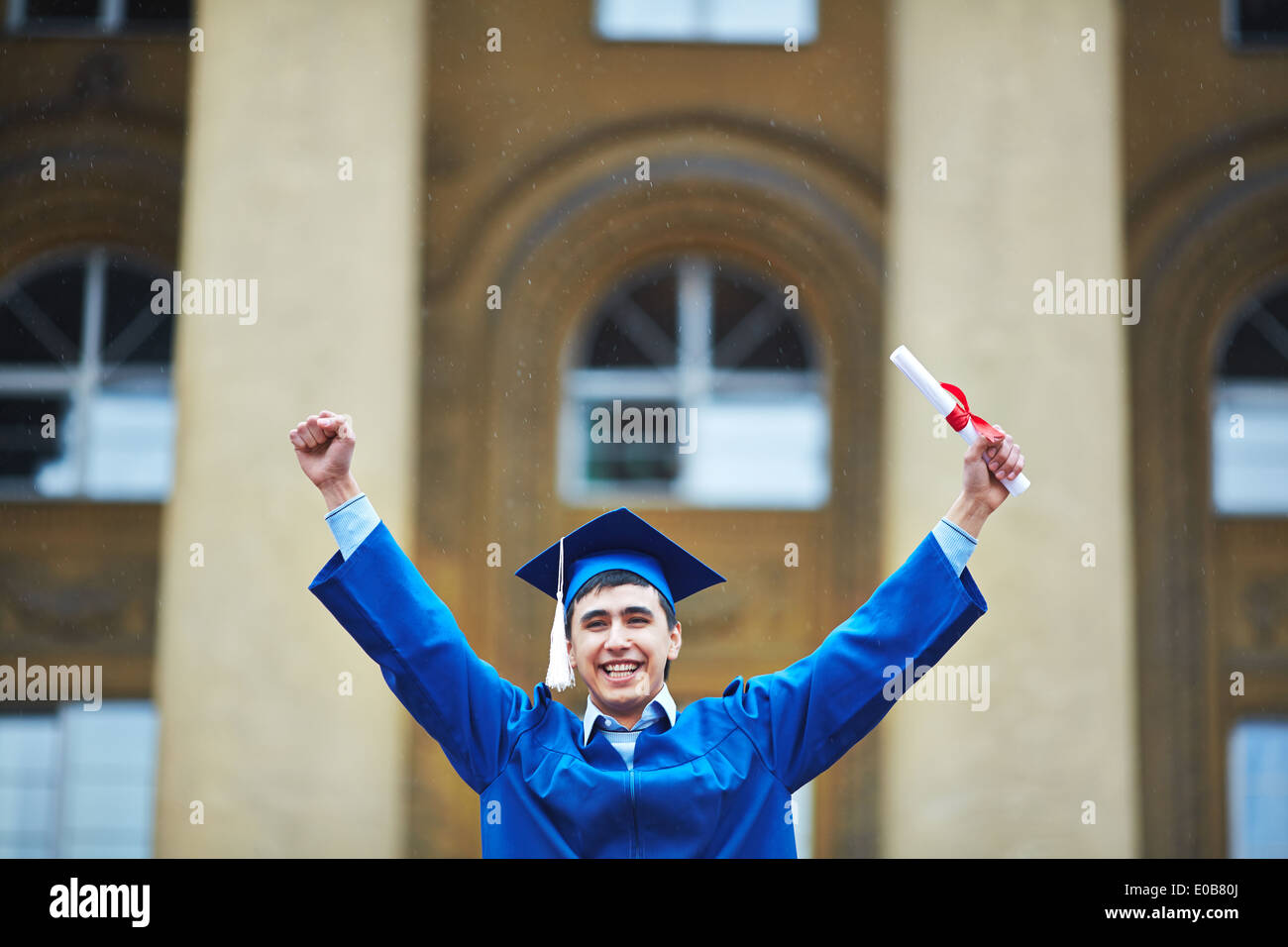 Portrait of confident student with graduation certificate showing gladness Stock Photo