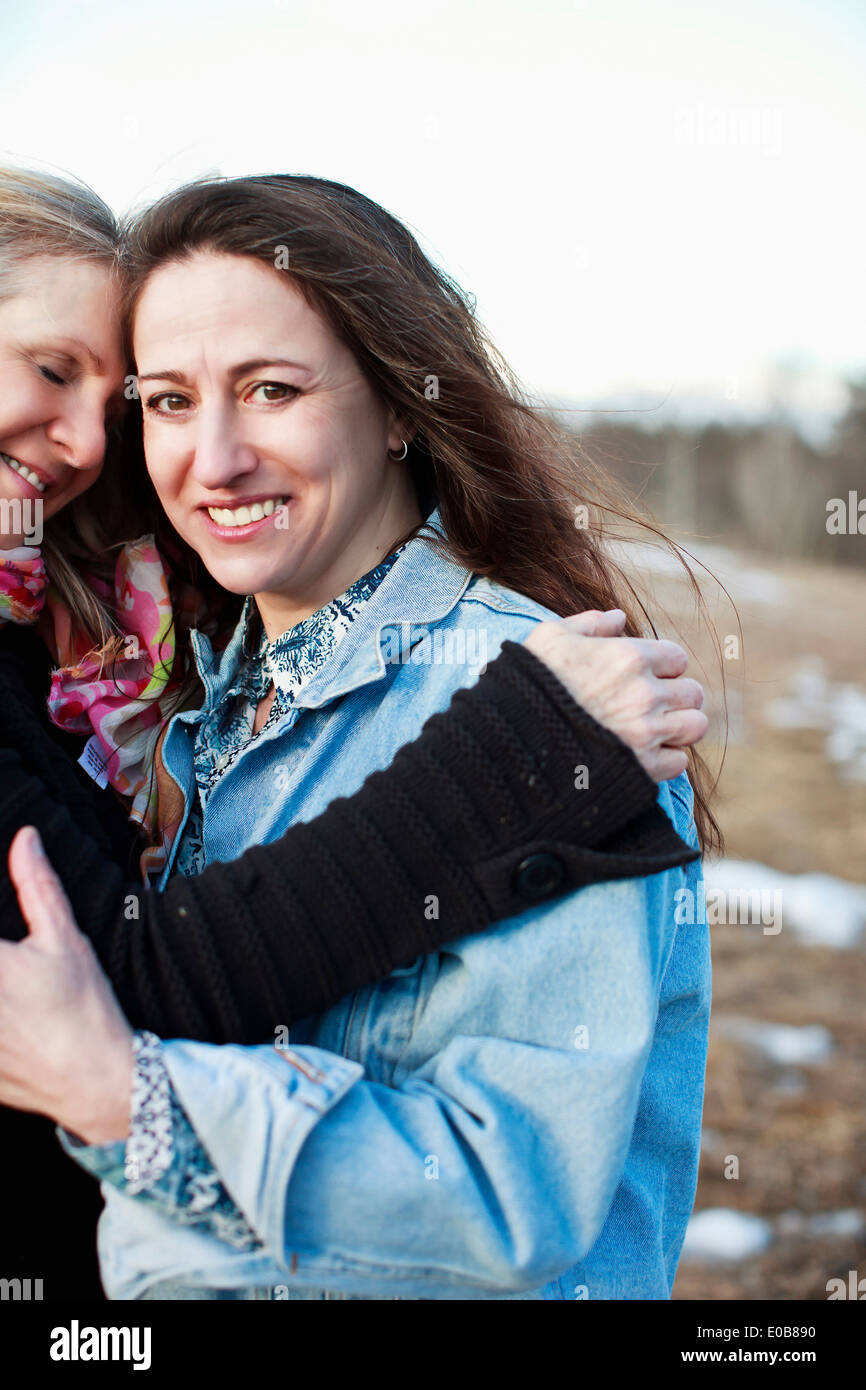 Portrait of mature women hugging outdoors Stock Photo