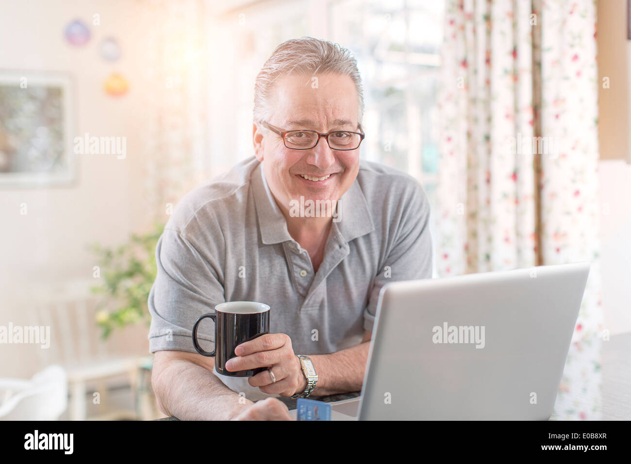 Mature man at home using laptop Stock Photo