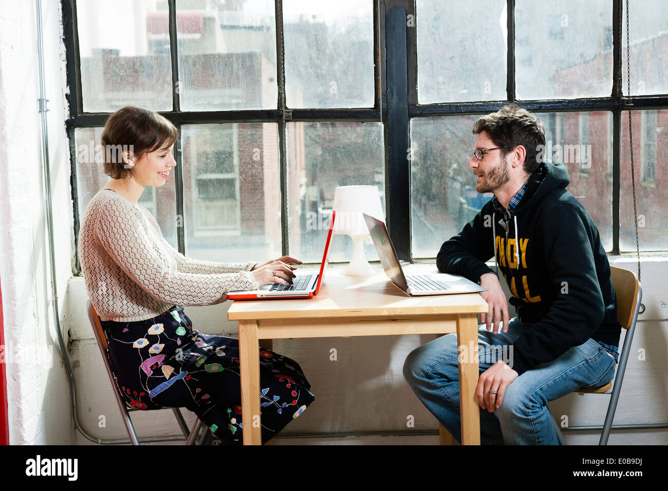 Male and female designers working on laptops in studio Stock Photo