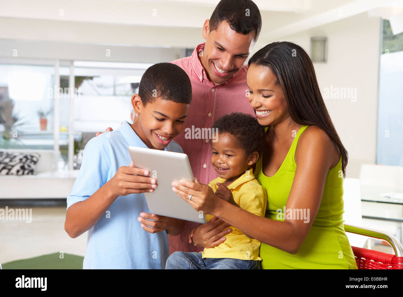 Family Using Digital Tablet In Kitchen Together Stock Photo