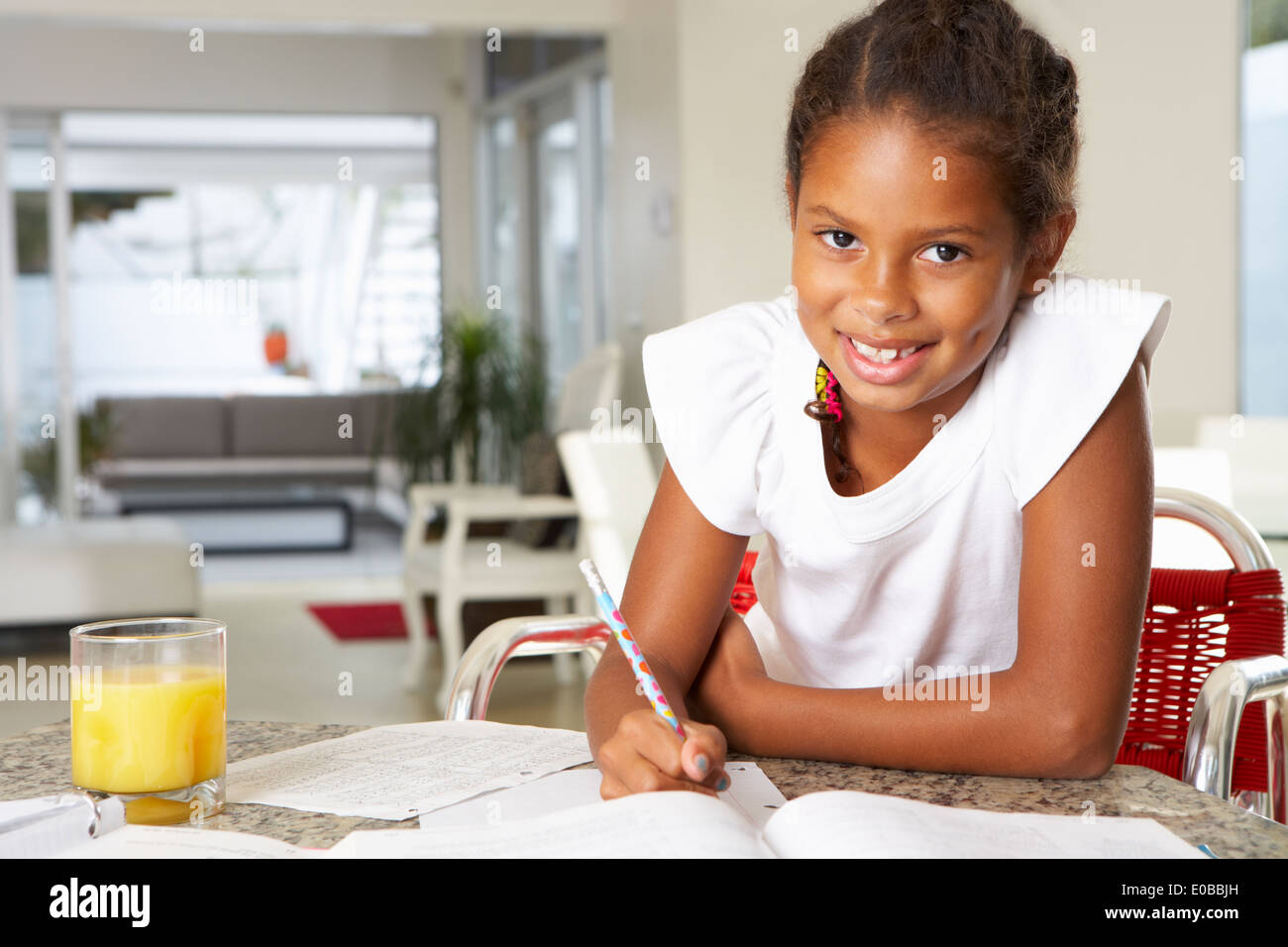 Girl Doing Homework In Kitchen Stock Photo