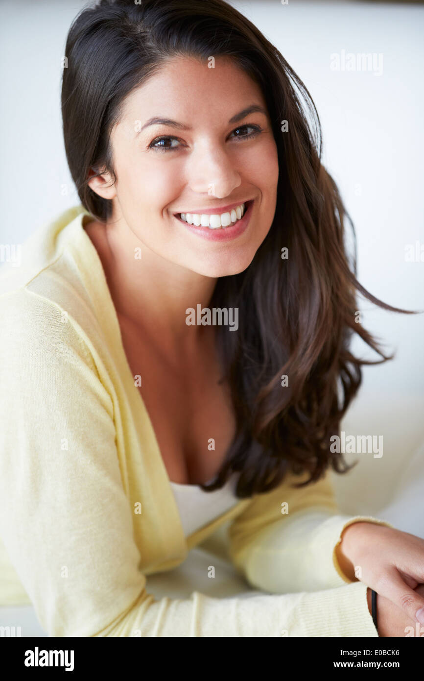 Smiling Woman Sitting On Sofa Stock Photo