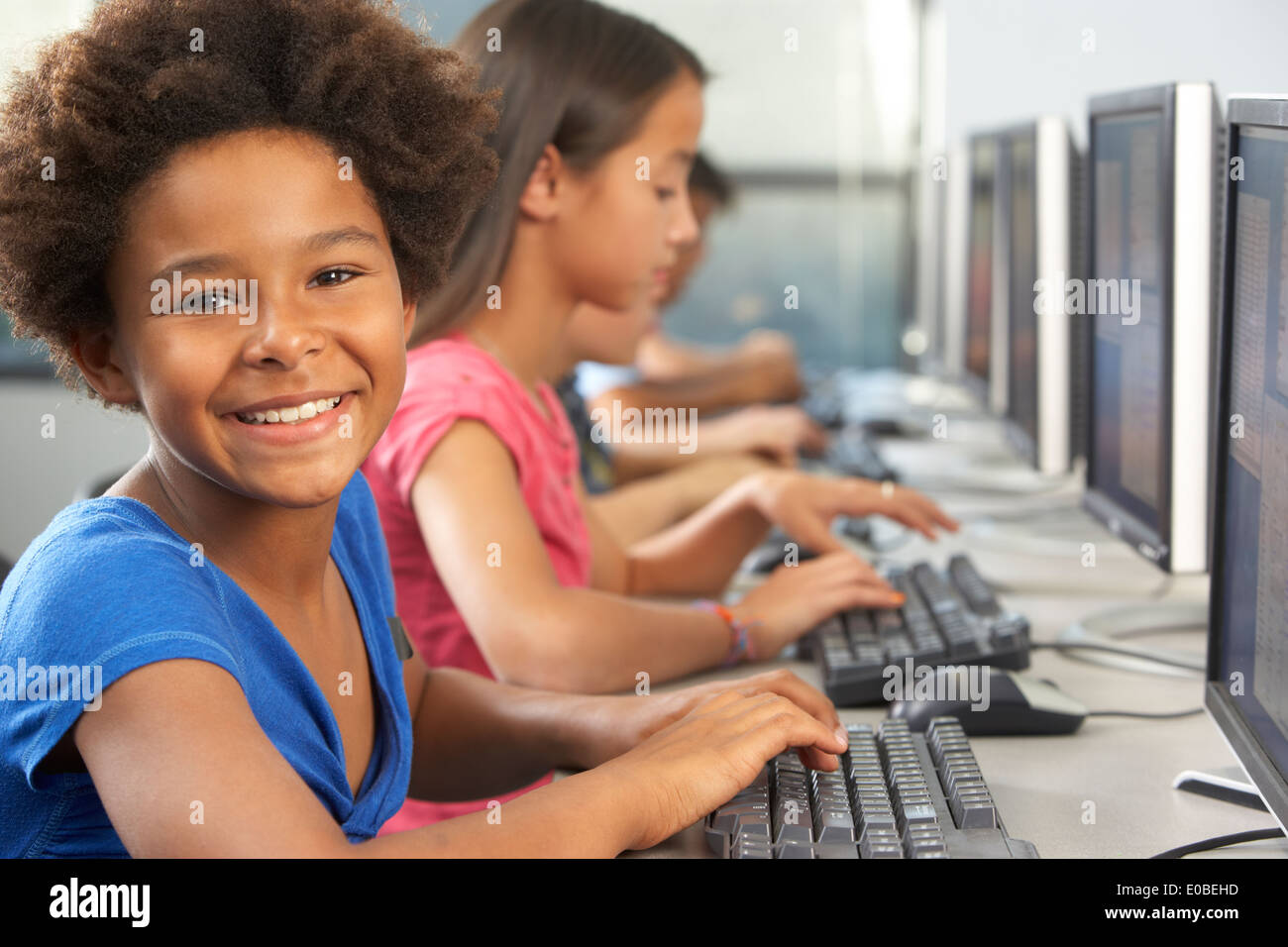 Elementary Students Working At Computers In Classroom Stock Photo