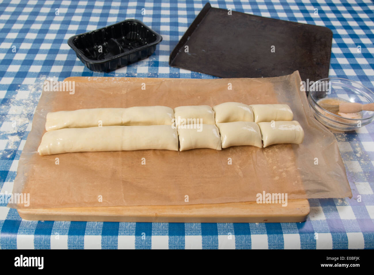 Making sausage rolls using ready rolled pastry and sausages cutting
